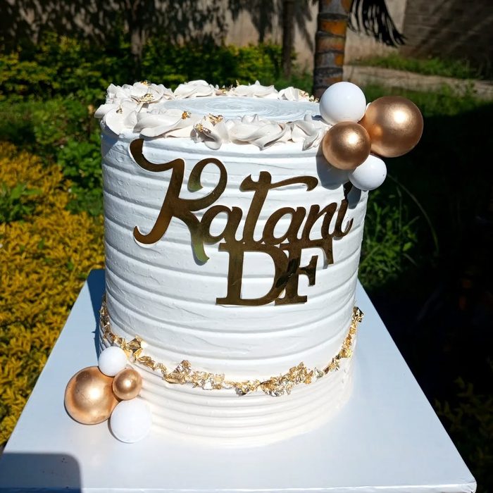 White and gold cake with balloon spheres and Kalani DF acrylic topper